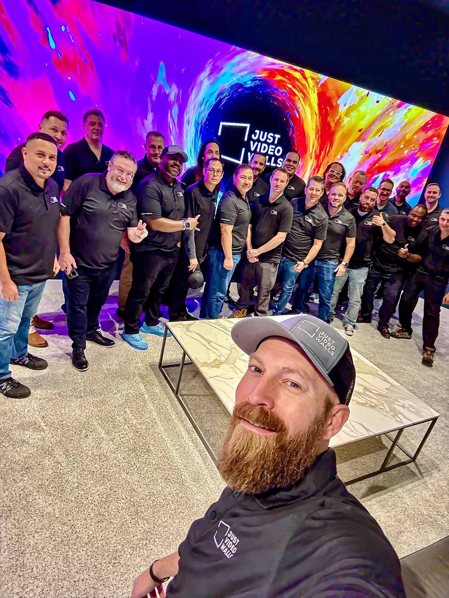 Just Video Walls team selfie in front of a MicroLED display