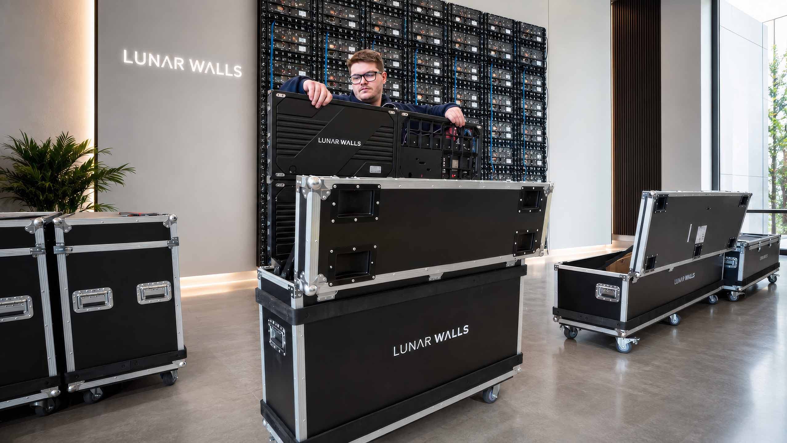 Technician lifting a Lunar Walls cabinet from an open shipping crate